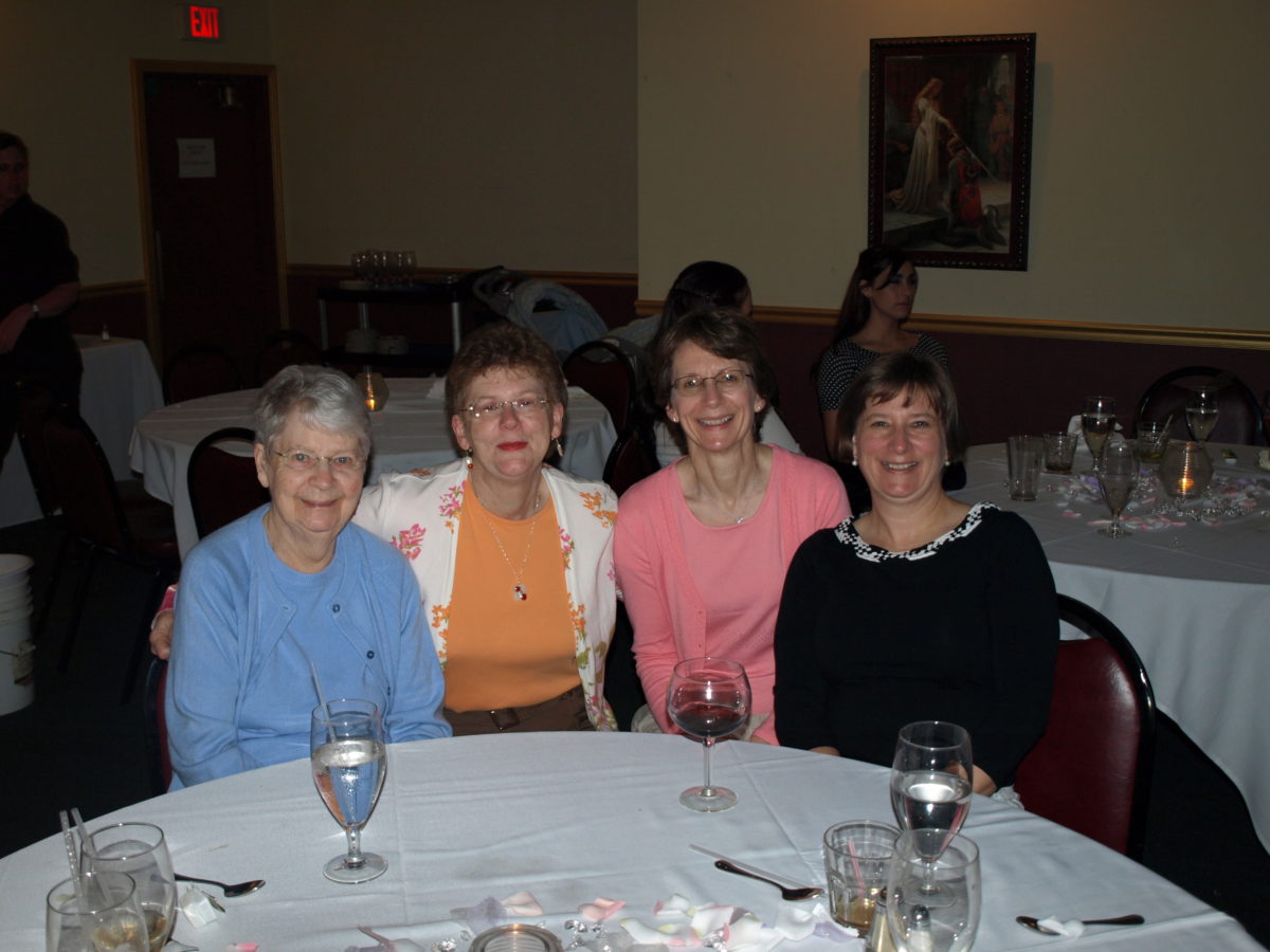 A photograph of Grandma, Aunt Ann, Jill, and Aunt Mary sitting at their table at Kelsey and Kevin's wedding.