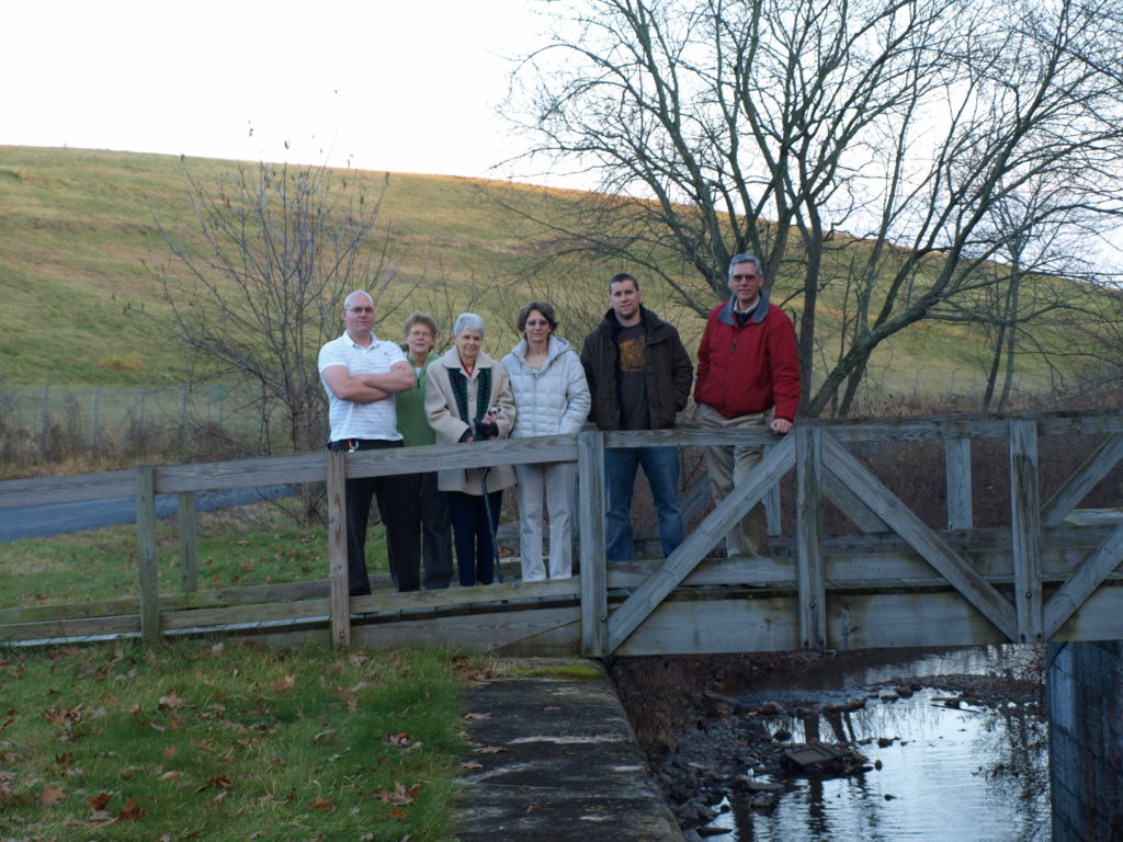 A photograph of Kevin, Aunt Ann, Grandma, Jill, Karl, and Paul standing on a bridge over the feeder canal in Hudson Falls NY.