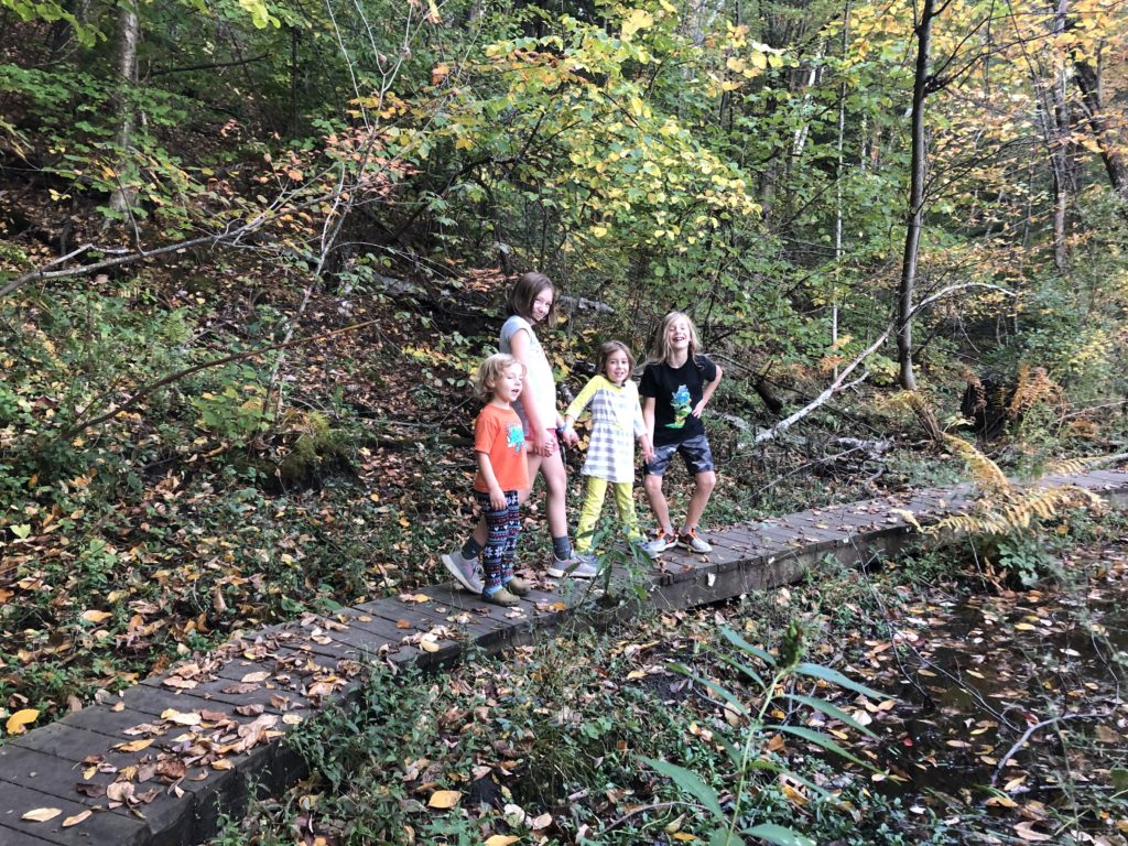 Forrester kids pose on a raised wooden path on one section of trail.