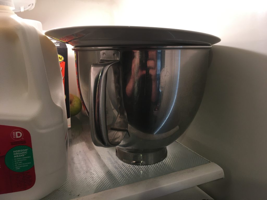 A photo of the Kitchen Aid metal mixer bowl, full of liquid ice cream, set in the refrigerator to chill.