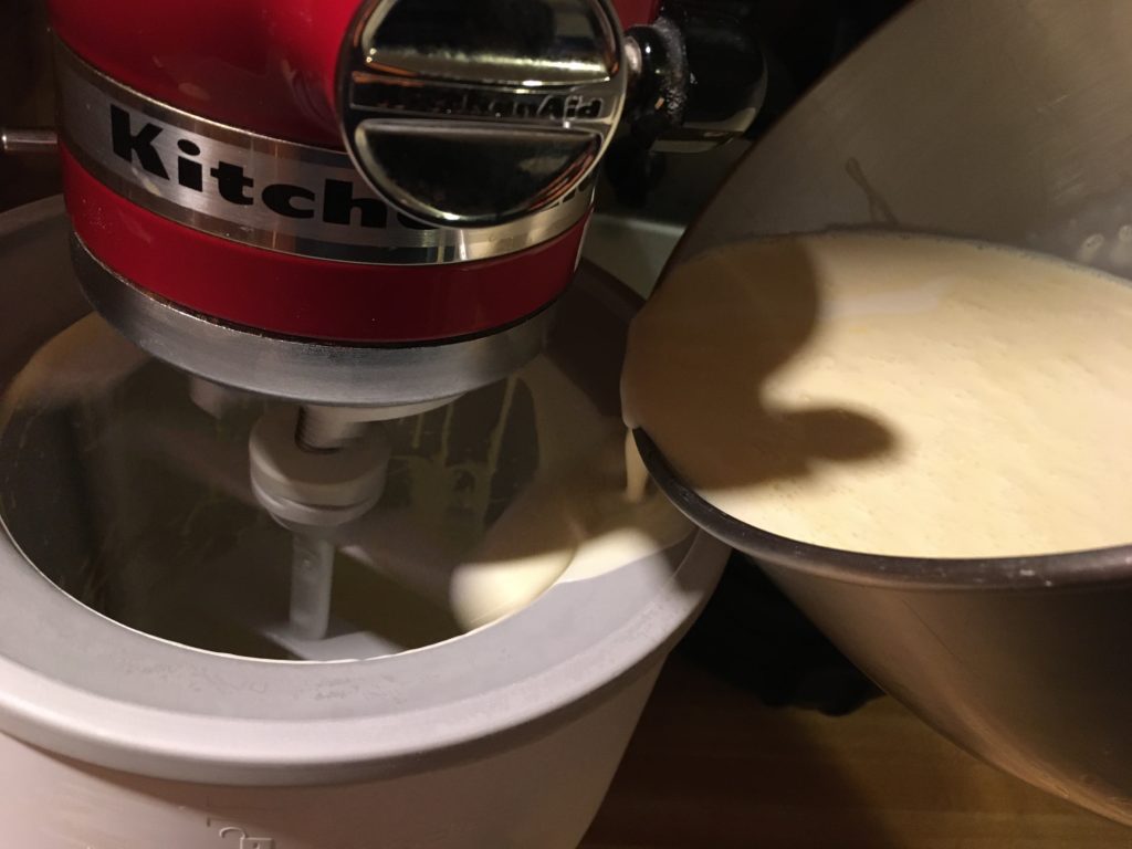 A photo of liquid ice cream being poured into the Kitchen Aid ice cream maker attachment to be churned.