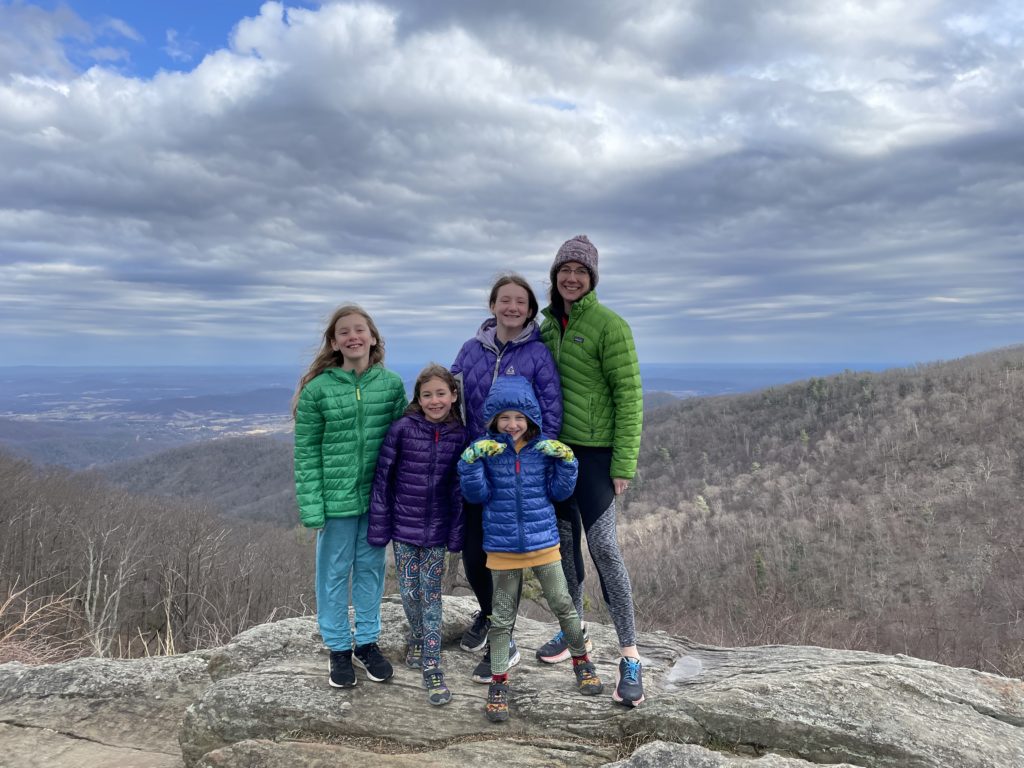 A photo of Dillon, Ainsley, Grayson, Rayleigh, and Kelsey standing on top of a large rock in Shenandoah National Park with the Appalachian mountains in the background