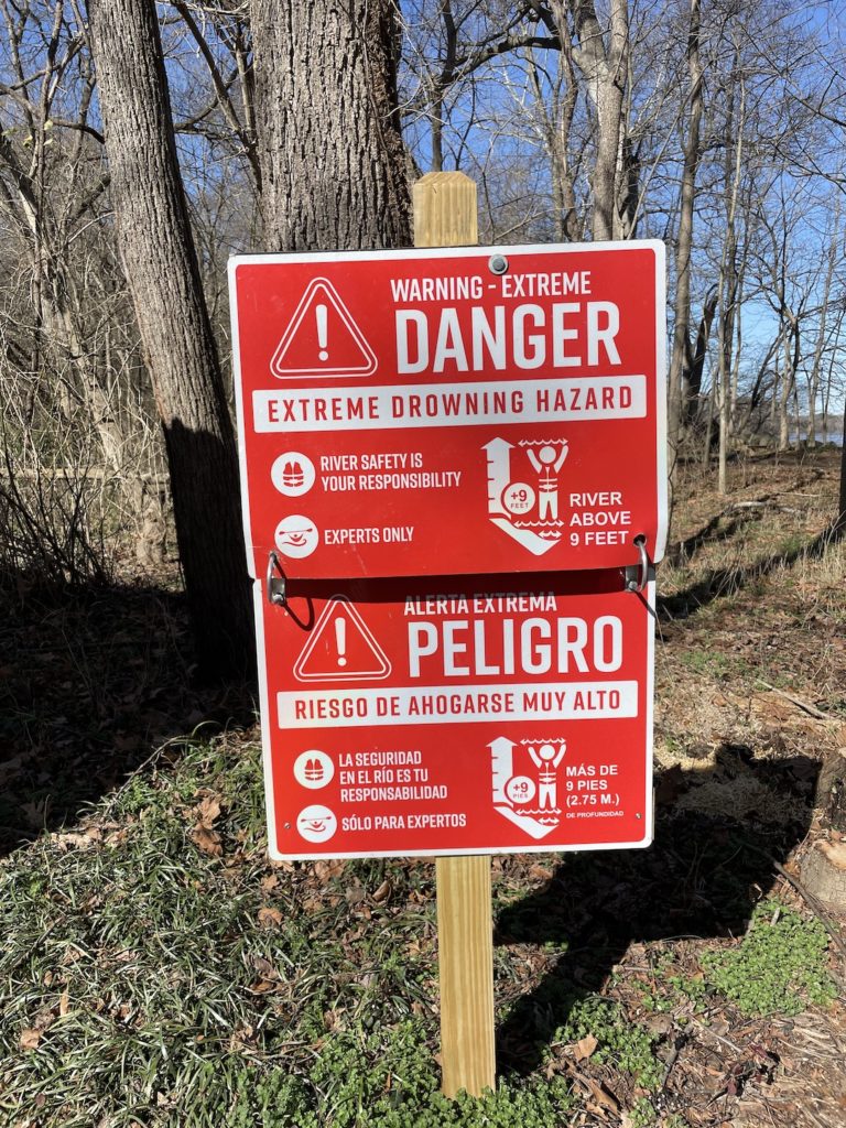 A photo of a sign that says "Warning - extreme danger: Extreme drowning hazard. River safety is your responsibility. Experts only. River above 9 feet."
