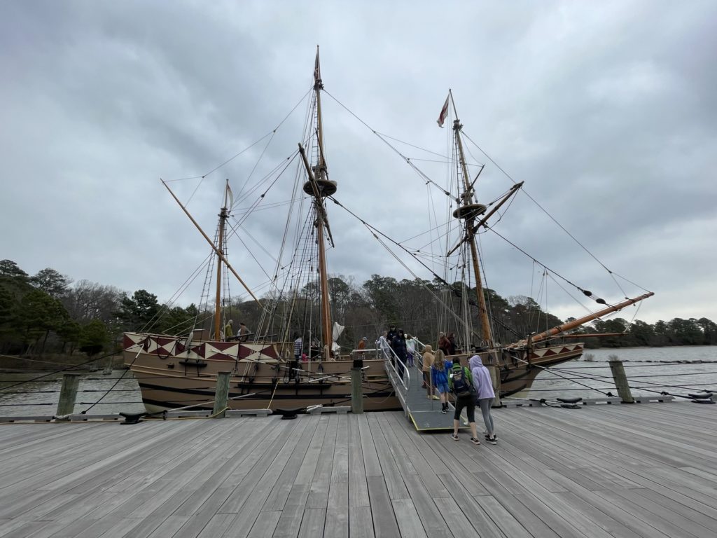 A photo of a 17th century ship sitting at anchor by a dock