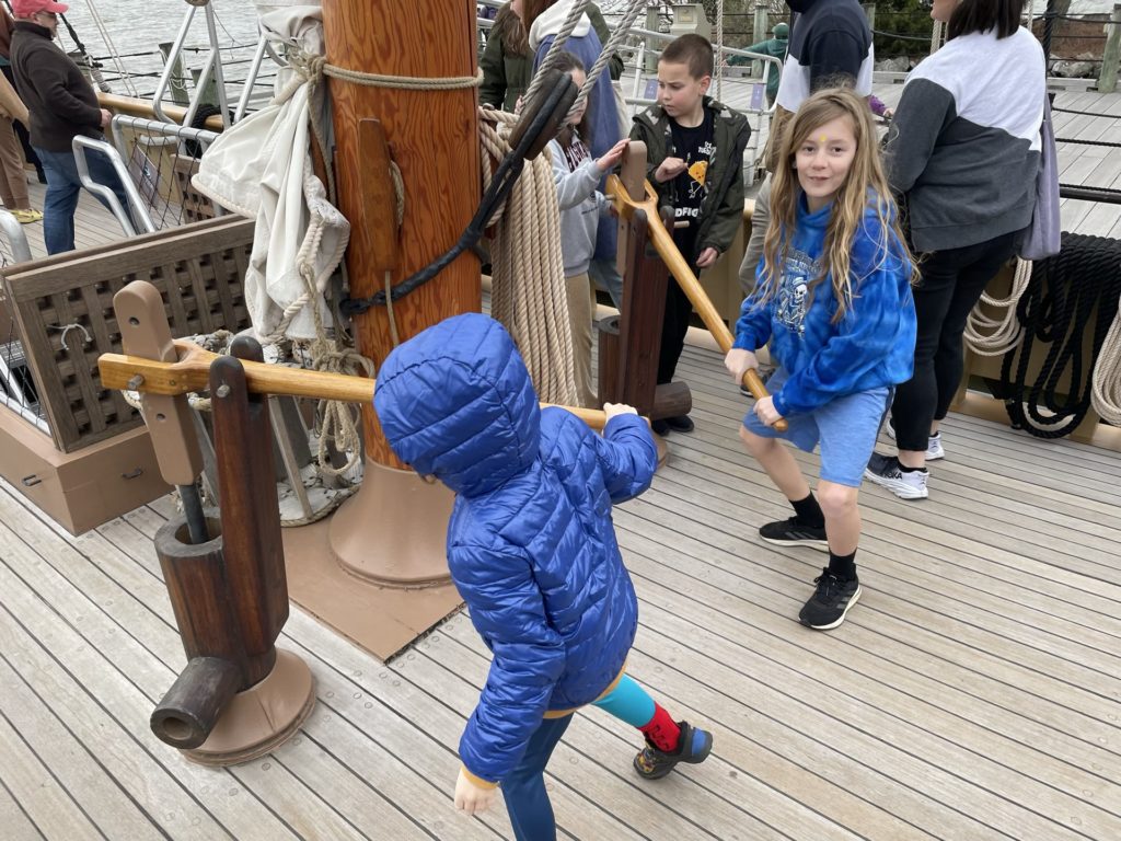 A photo of Grayson and Dillon operating the bilge pumps on a 17th century ship