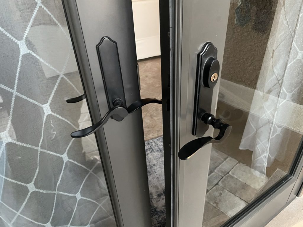 A photo of a door with the door handle put on backwards sitting ajar because it can't close due to the handle pointing the wrong way