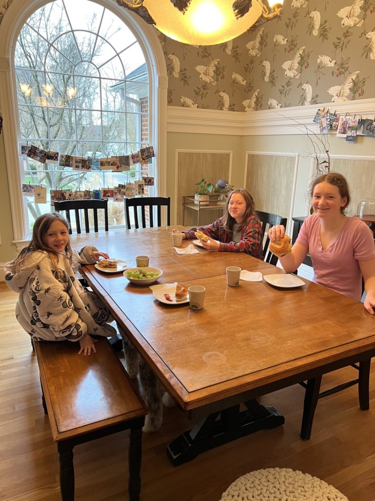 A photo of Olivia, Evie, and Rayleigh eating breakfast at the Picks' house