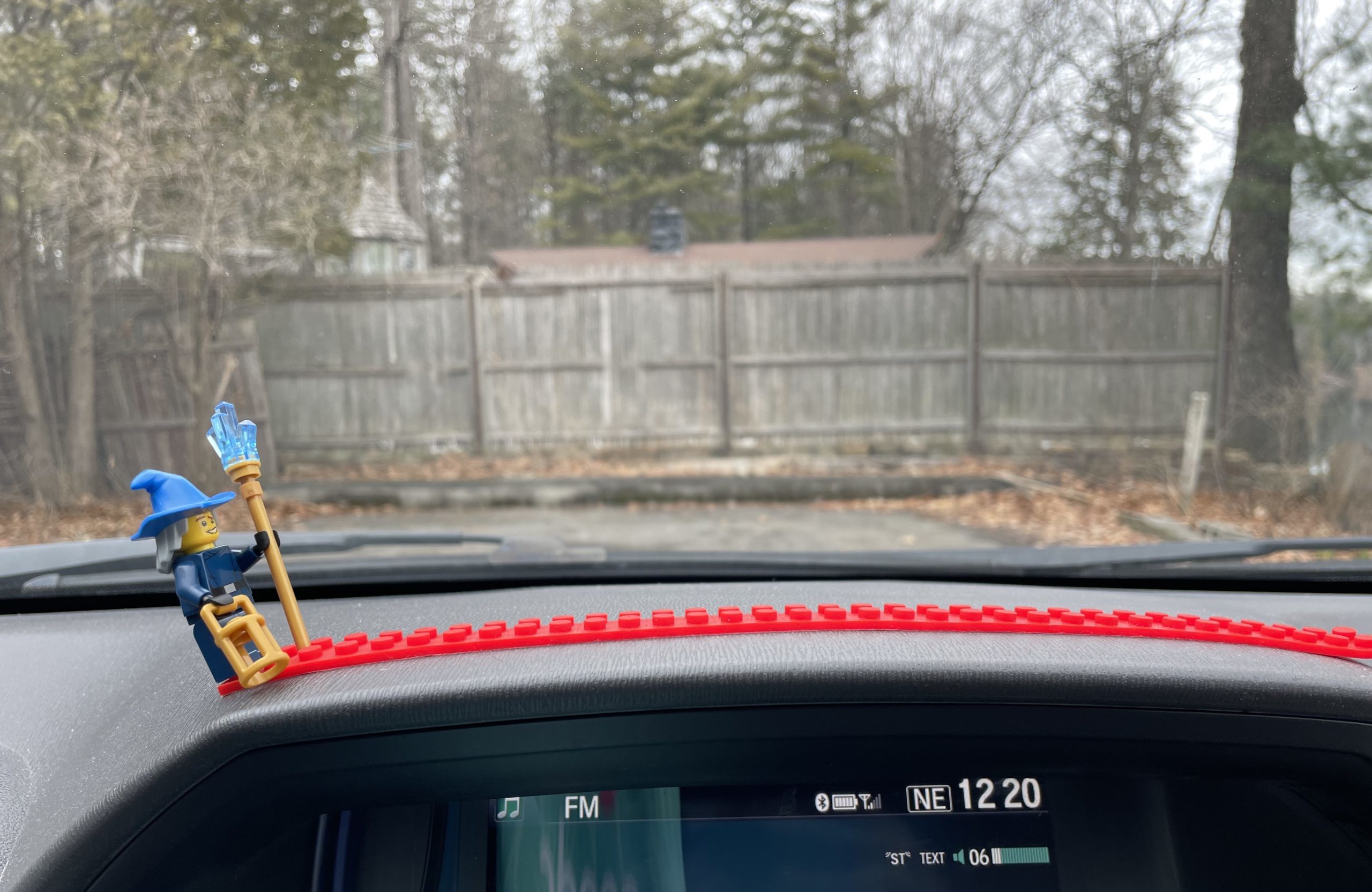 A photo of a Lego wizard on a red track on the dashboard of our van