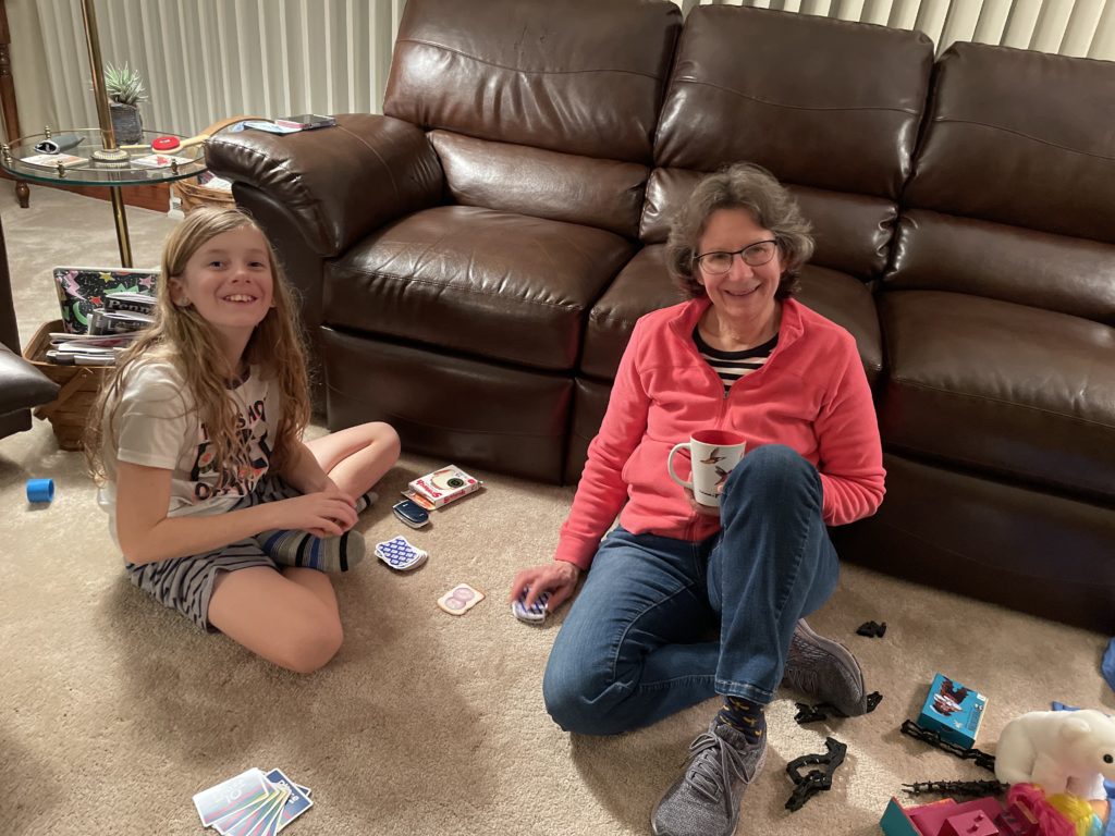 A photo of Dillon and Mimi playing cards on the living room floor
