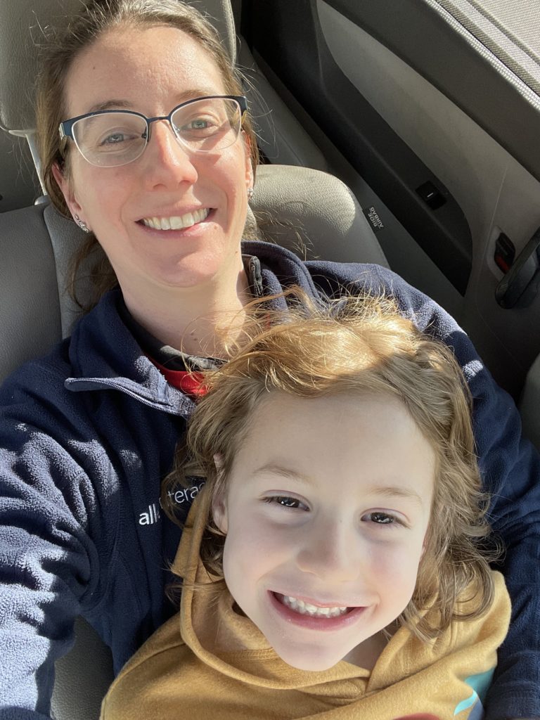 A photo of Grayson sitting on Kelsey's lap in the van while parked and waiting for everyone else to return from a hike