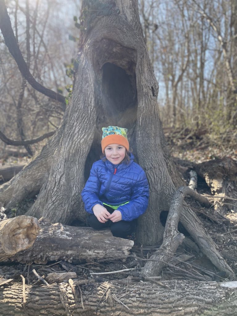 A photo of Grayson sitting in the hollow of a tree
