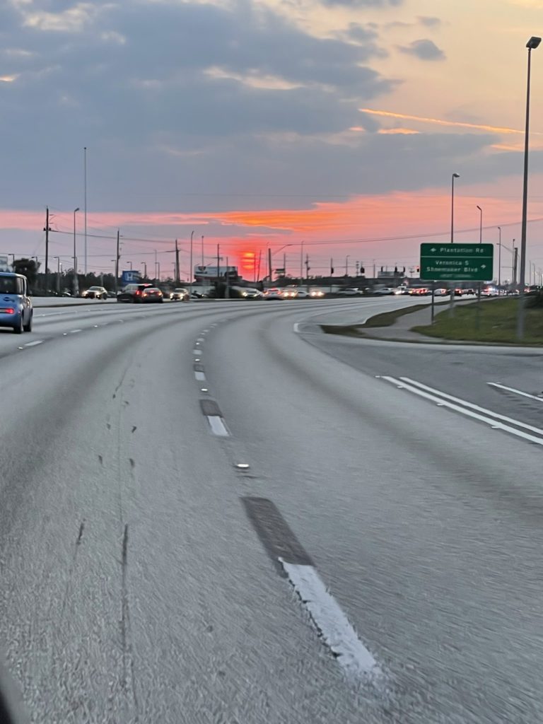 A photo of an orange sunset over the highway