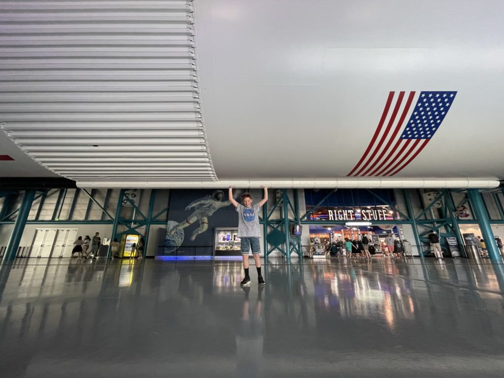A photo of Dillon appearing to be holding up the massive Saturn V rocket over his head through a trick of perspective