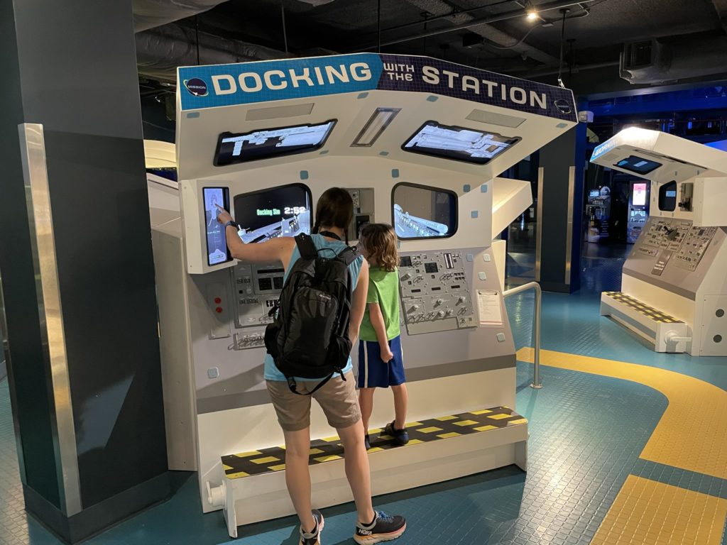 A photo of Kelsey helping Grayson try his hand at the docking simulator