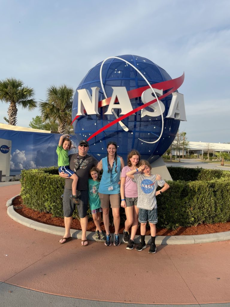 A photo of Grayson, Kevin, Ainsley, Kelsey, Rayleigh, and Dillon in front of a 3-D NASA globe logo