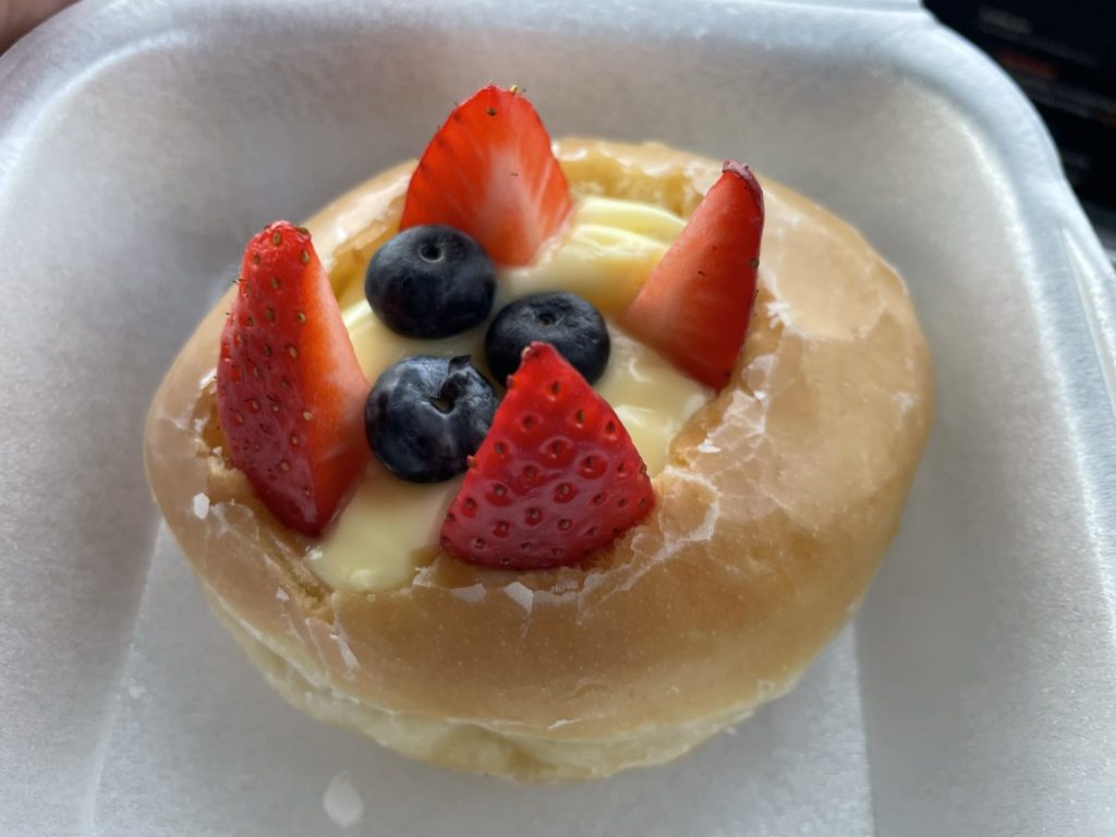 A photo of a doughnut with Bavarian creme, strawberries, and blueberries