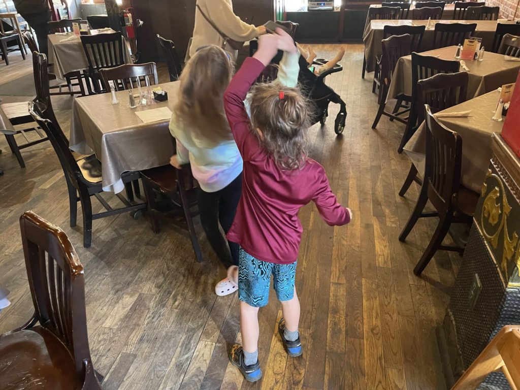A photo of Grayson twirling Ainsley while dancing to live music in a restaurant
