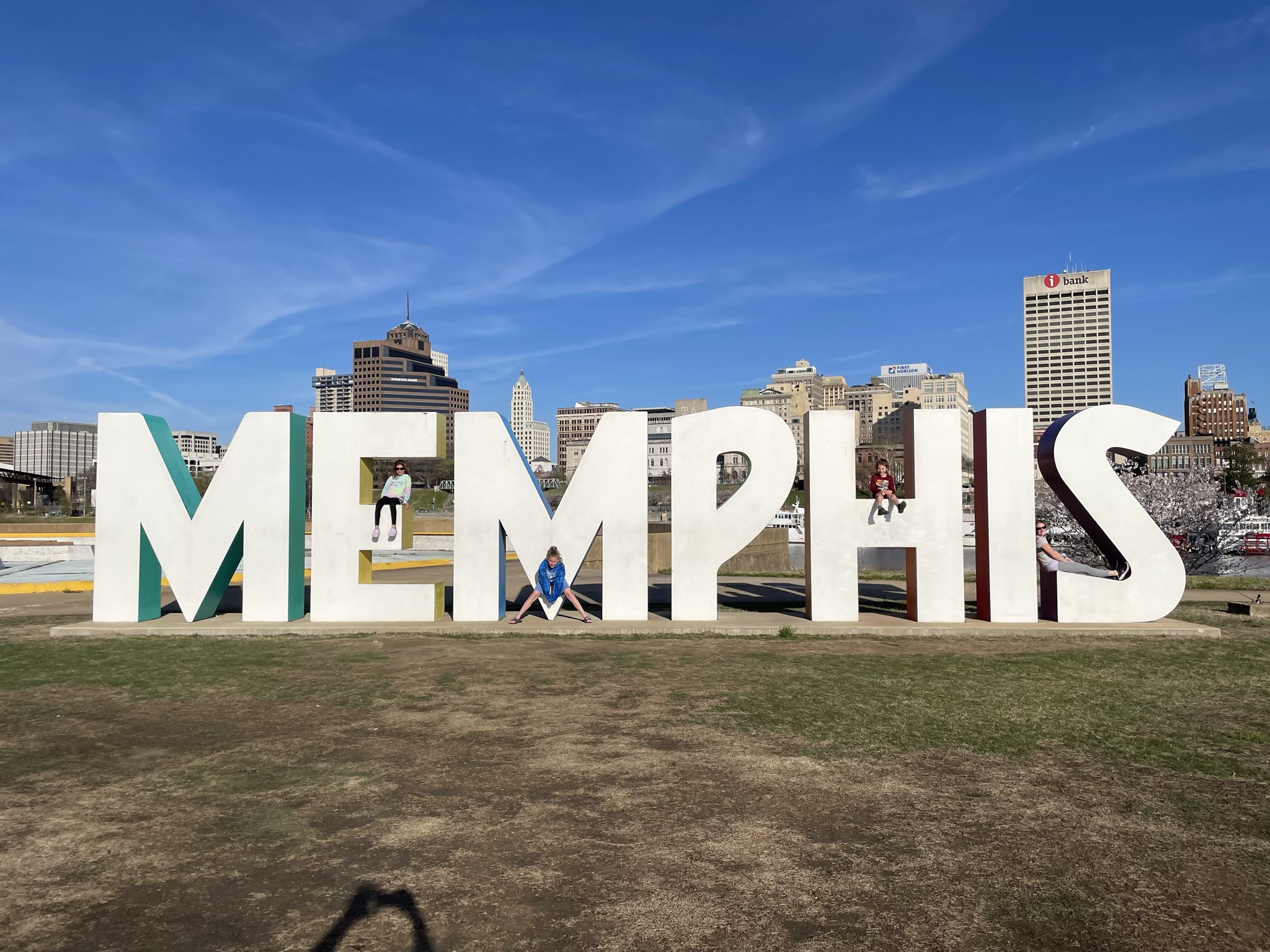 A photo of Ainsley, Dillon, Grayson, and Rayleigh on a giant Memphis sign with the city of Memphis in the background