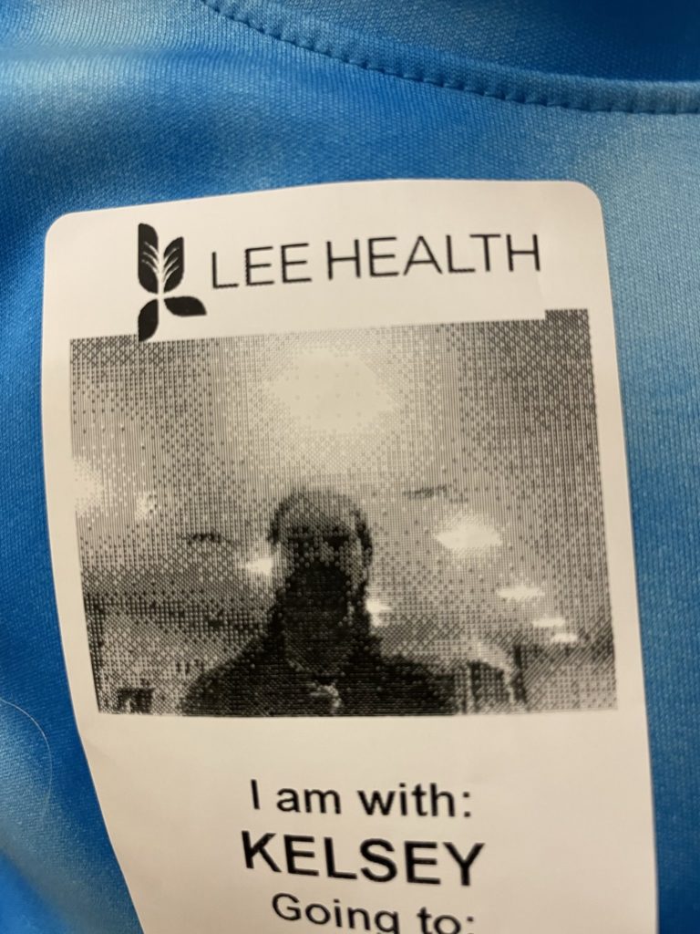 A photo of Kelsey's hospital visitor badge with a very low-resolution photo of her face
