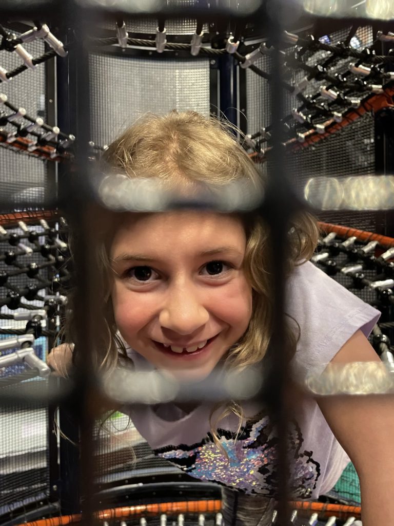 A photo of Ainsley in a tunnel, taken through the wire mesh that forms the tunnel wall