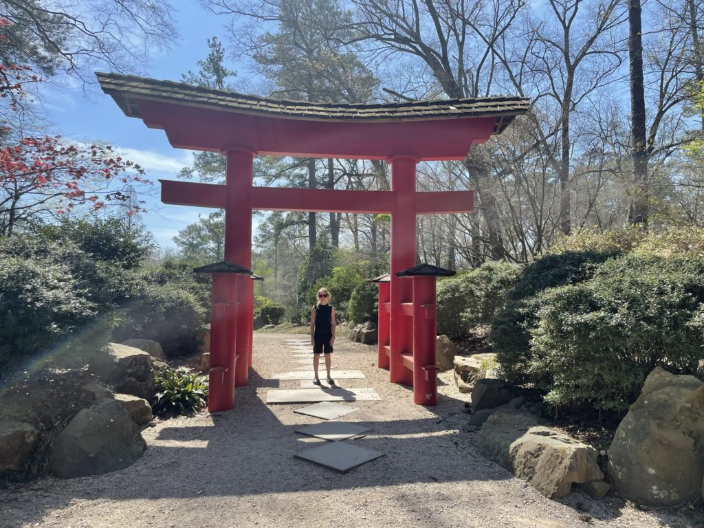A photo of Dillon under a torii, or red Japanese gate