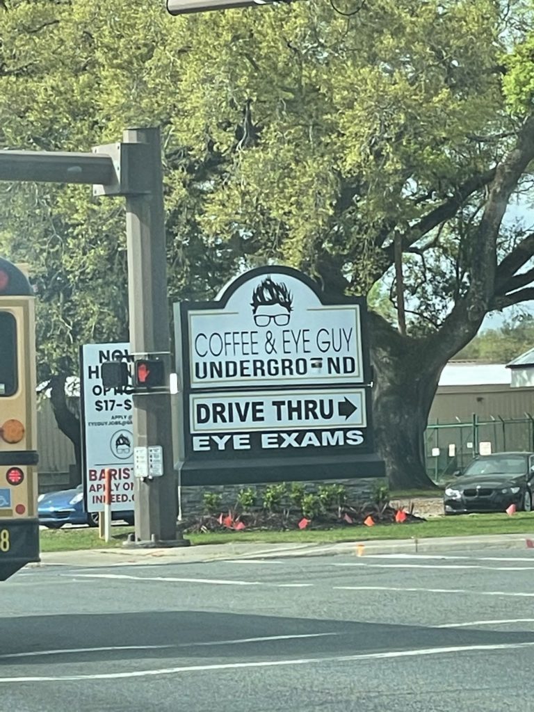 A photo of a sign that says "Coffee and eye guy: underground. Drive thru eye exams"