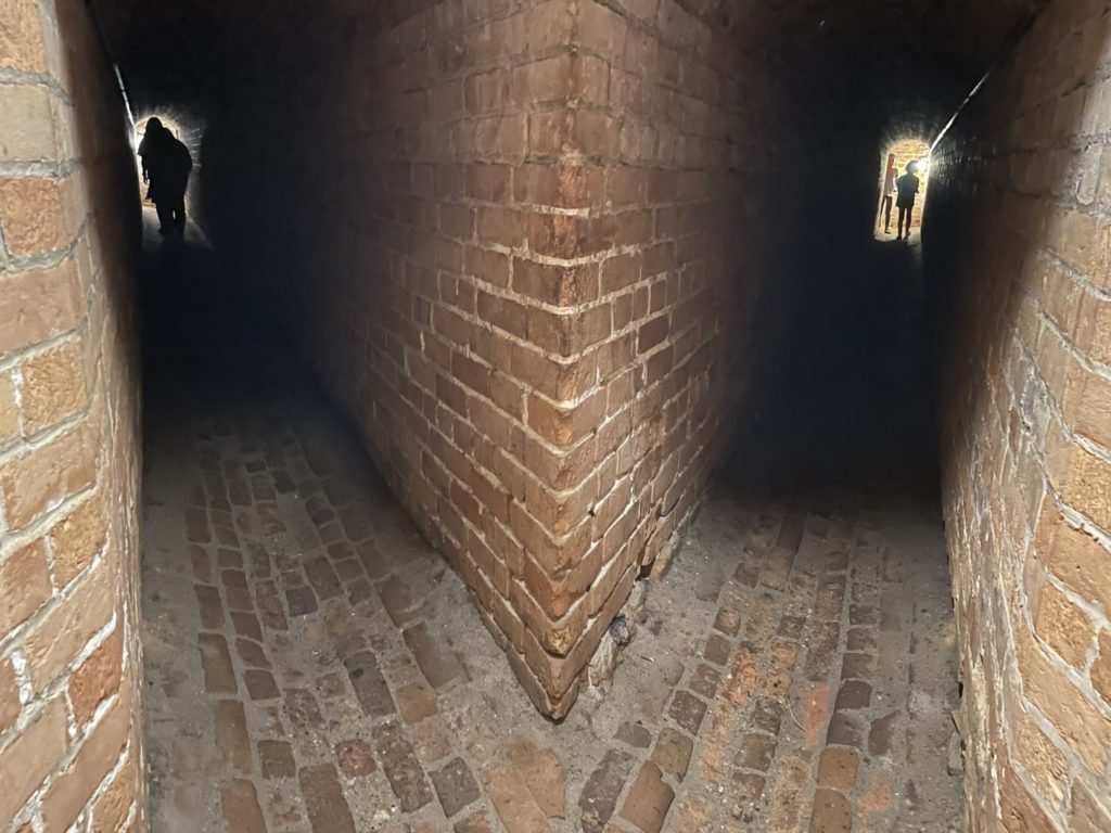 A photo of two narrow brick hallways going off to the left and right