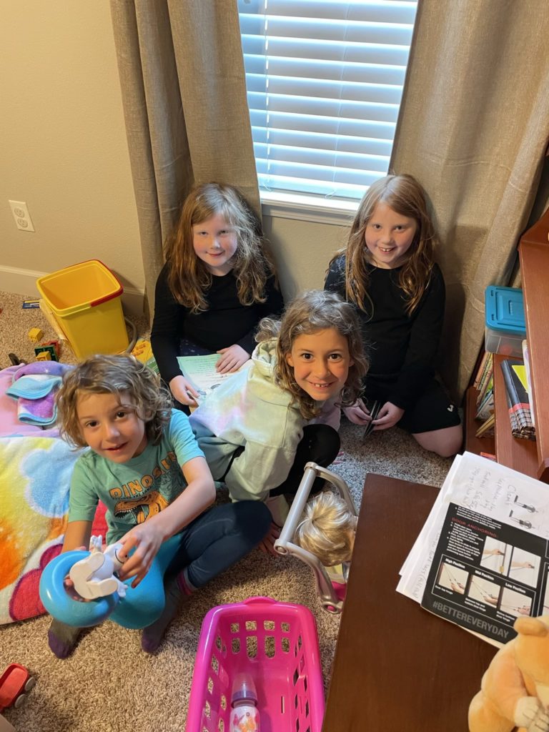 A photo of Hailey, Harper, Grayson, and Ainsley playing with toys indoors