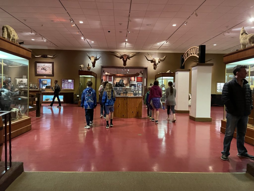 A photo of the inside of the Woolaroc museum, which includes stuffed wildlife such as wolves, longhorn cattle heads, and several displays about ranching.