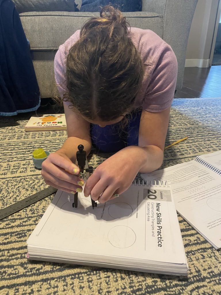 A photo of Rayleigh using a mathematical compass to do math homework.