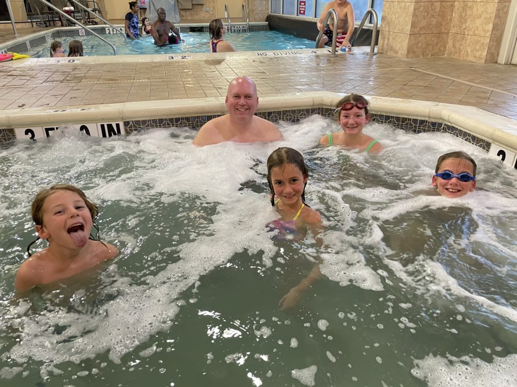 A photo of Grayson, Kevin, Ainsley, Rayleigh, and Dillon in the hot tub at the hotel