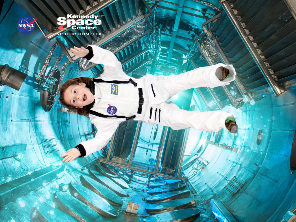 A photo of Grayson in an astronaut costume appearing to float weightless in a space station