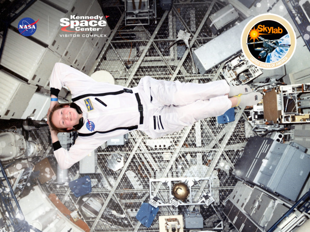 A photo of Rayleigh in an astronaut costume appearing to float weightless in a space station