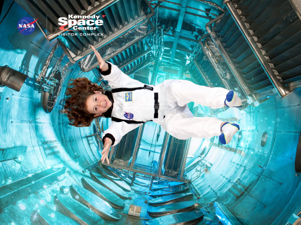A photo of Ainsley in an astronaut costume appearing to float weightless in a space station