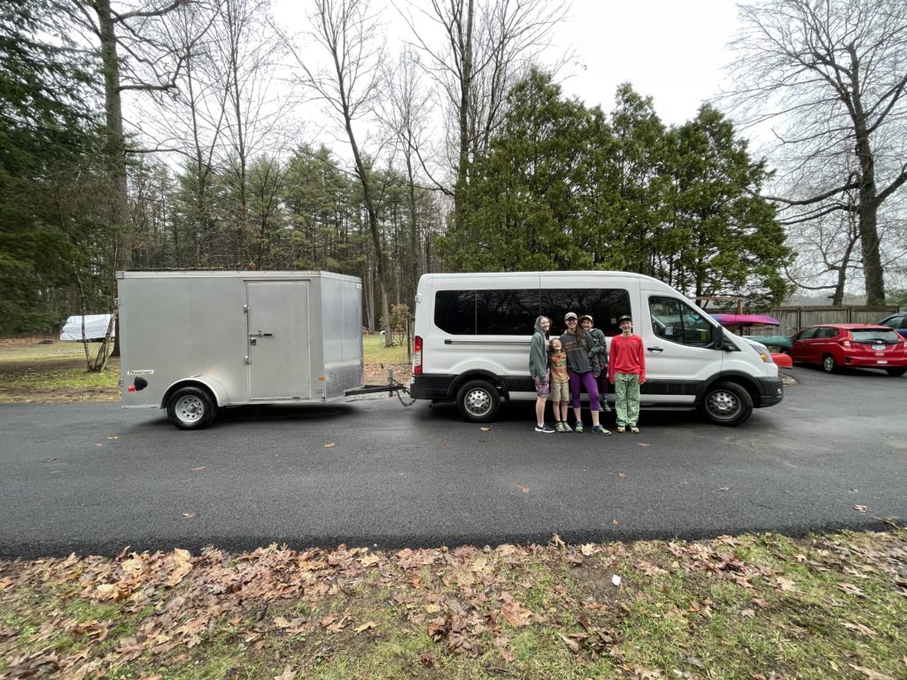 Efffffing Family in front of white van and trailer.